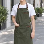 Tạp dề đồng phục yếm cúc điều chỉnh màu xanh rêu, vải kaki thun, phối da nhân tạo