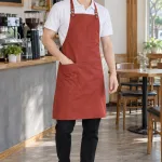 Tạp dề đồng phục yếm cúc điều chỉnh màu đỏ gạch, vải vải chống thấm, túi ngực nhỏ